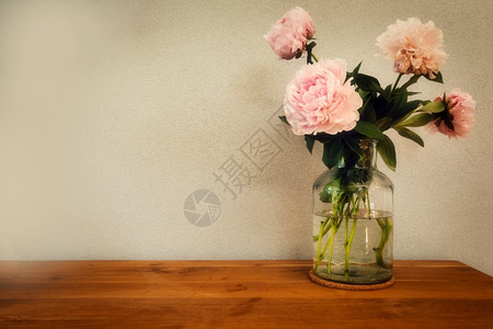 木桌上玻璃花瓶中的粉色牡丹图片
