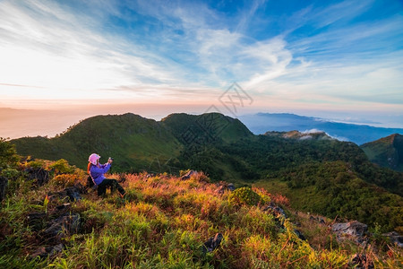 泰国淑女青春子在日落时拍摄照片在山上看风景远足图片