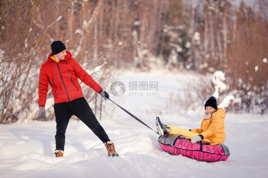 父亲和孩子的年轻幸福家庭在冬季户外玩得开心父亲和孩子们在圣诞节前夕渡过夜户外度假爸帽一月图片