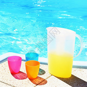 泳池边的饮料和彩色杯子图片