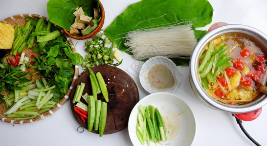 越南高端素食健康用植物蔬菜绿色热锅自家由番茄花粉龙豆草叶菠菜豆腐皮和干面条制成豌豆起司最佳背景图片