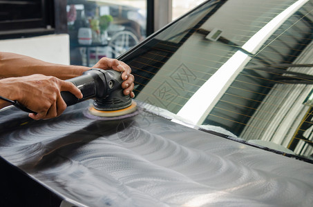 机械负责打磨涂层汽车擦面的男子在车面后会帮助消除车面表的污染物在擦车面之后将发光站店铺背景图片