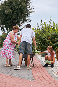 绿色爱好户外孙子女帮助祖母在家庭花园里孩子们真正的瞬间实情境图片