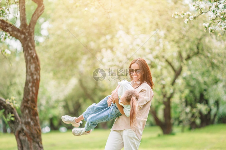 呼吸景观白种人母女一家在花园里户外玩乐母女一家在盛开的樱桃园里图片
