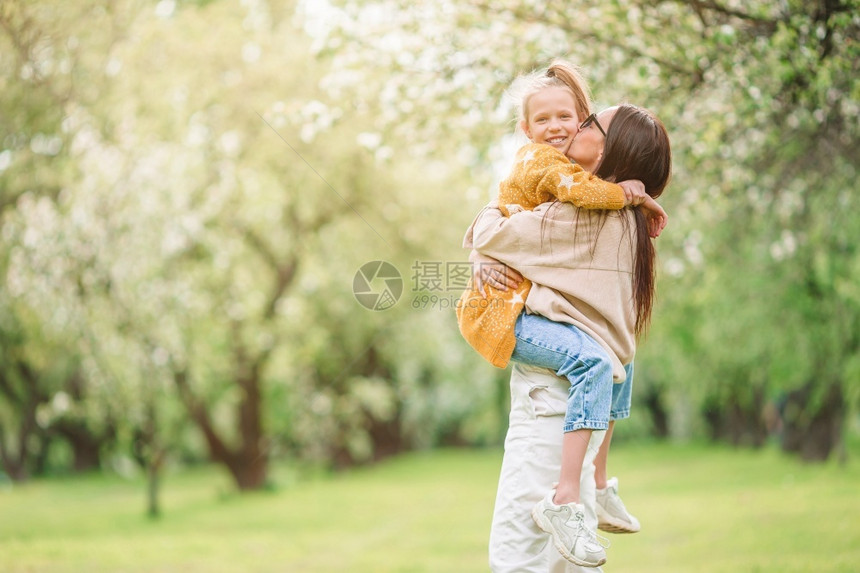 樱桃闻水果母亲和女儿的家庭在公园户外玩得开心在盛的樱花园中母亲和女儿家庭图片