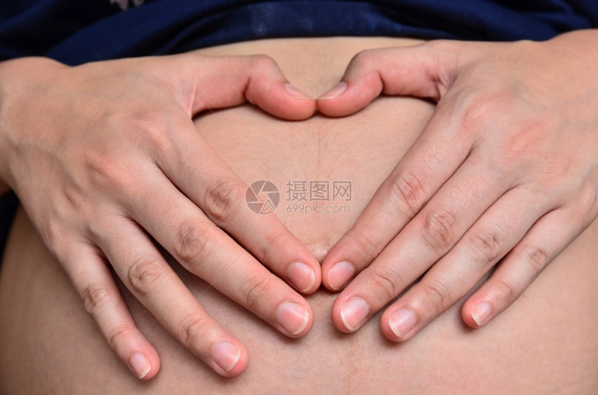 开端怀孕妇女用双手在肚子上心脏结为按钮妻子图片