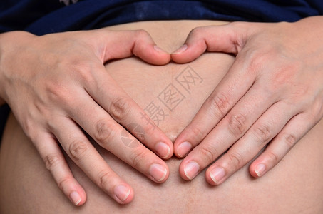 开端怀孕妇女用双手在肚子上心脏结为按钮妻子图片