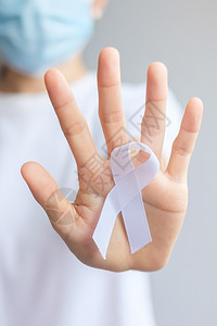 手拿白色丝带预防癌症概念特写背景图片