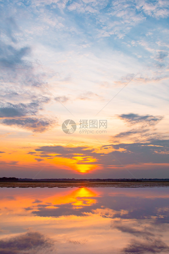 丰富多彩的太阳日落反射环礁湖云和蓝天空之后的美丽日落浮云之上的蓝天在环礁湖风景背下戏剧天空日落时有云在后面图片