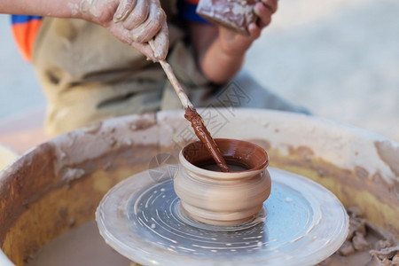年轻陶匠的手在圆圈上制造一个土罐子痣杯男生图片