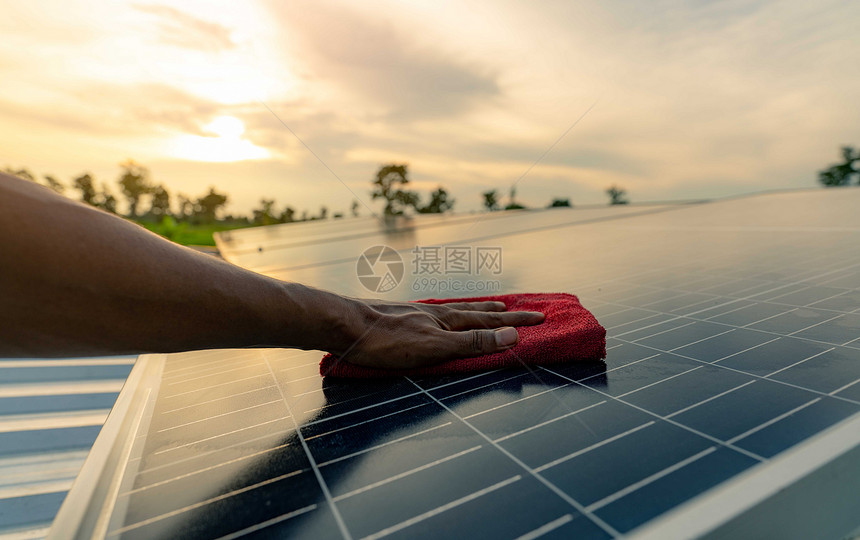 在屋顶太阳能电池板或光伏模块维护上用清洁太阳能板的人清洁太阳能板可持续源和再生用于绿色概念未来能源利用太阳技术的应用为绿色源使用图片