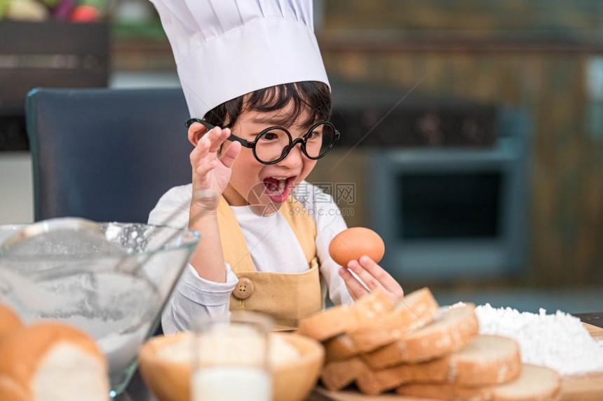 亚洲快乐的小男孩对在家厨房烹饪有趣而感到惊讶和兴趣的人生活方式和家庭自制食物及原料概念烤圣诞蛋糕和饼干人们的生活方式以及家庭自制图片