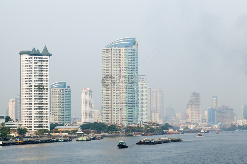 黎明曼谷市有许多高的建筑毗邻河流船只交通亚洲夜晚图片