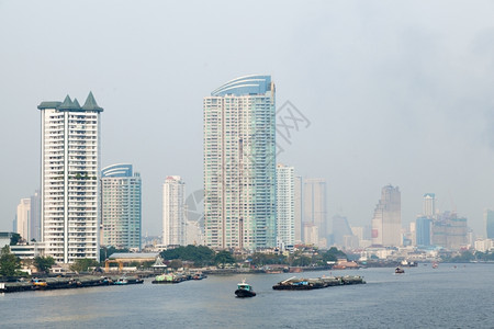 黎明曼谷市有许多高的建筑毗邻河流船只交通亚洲夜晚图片