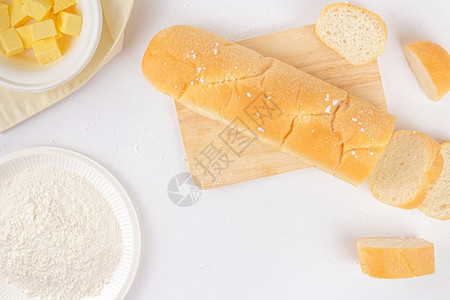 面包几片木板和一碗黄油放在白色的场景上一碗奶油所有的糕点别针图片
