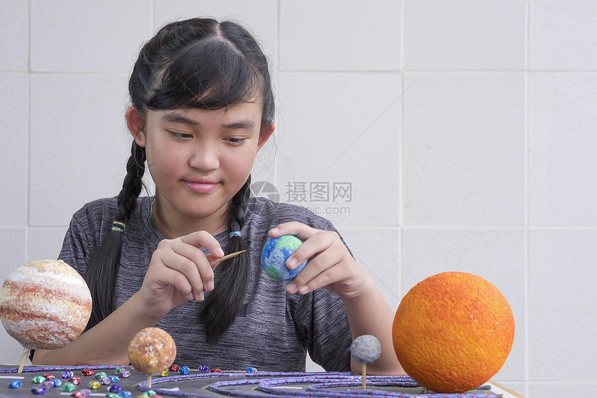 火星系统年轻的选择地关注亚洲年轻女孩在学校科功课项目中在家里木板桌上自制太阳系模型的自制太阳系模型图片