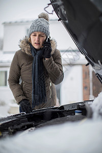 垂直的女摩托车手在雪中倒下呼吁为移动电话提供路边援助冰帮图片