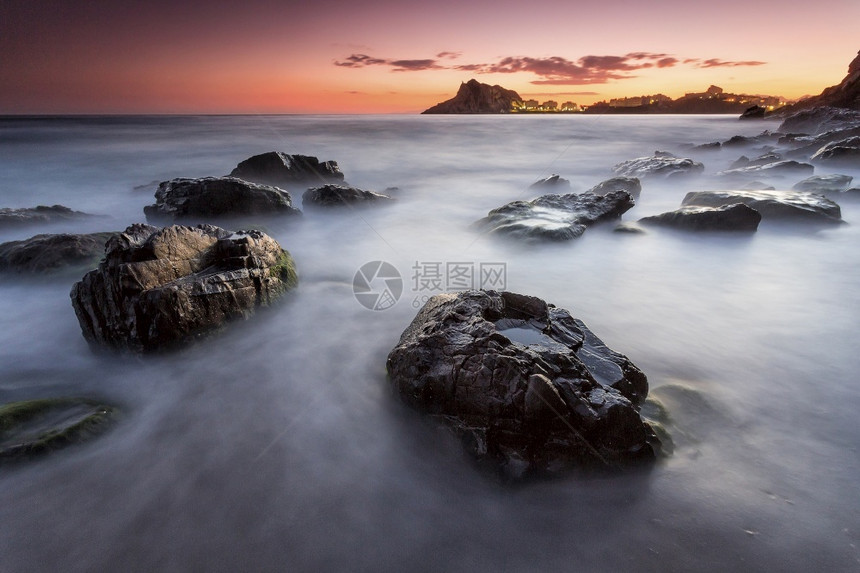 前景热带日落时表面有岩石的海景太阳图片