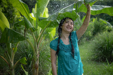 农场在绿花园背景下雨时一位年轻亚洲女身着香蕉叶的黑头发肖像年轻的快乐图片