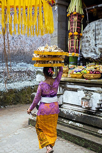 阿尼森岩印度尼西亚巴厘2019年月日妇女头顶上水果篮在寺庙献祭结石佛普鲁背景