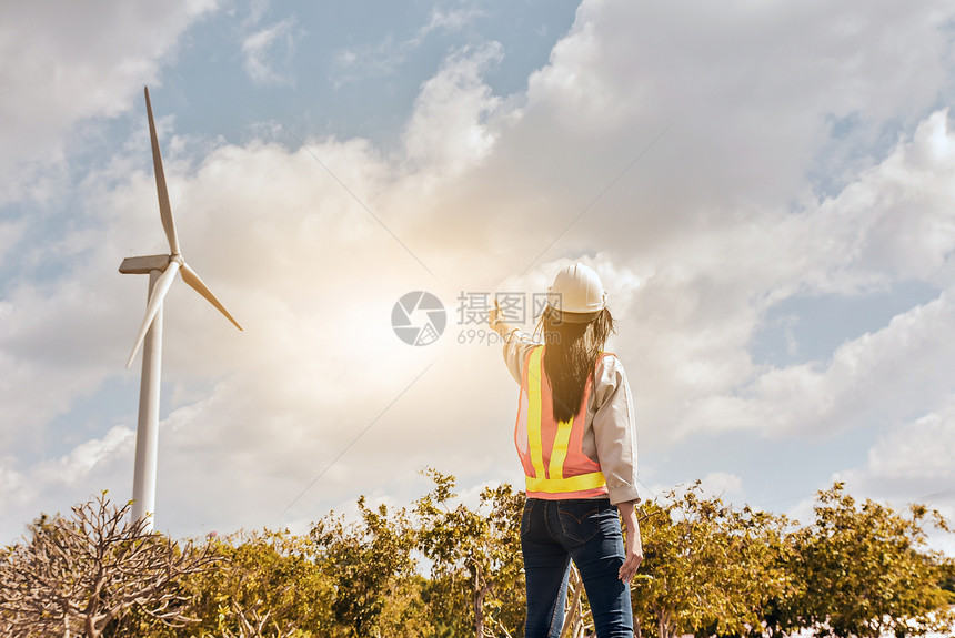 头盔工程师持站在山上和公园的天空风涡轮机发电站着从风中产生电力是一种清洁能源而通过风发电则是一种清洁能源效率行业图片