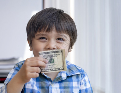 十英镑钞票银行业有选择焦点快乐小学生显示五美元男孩子持有钞票捐款或储蓄资金的未来小男孩得到了钱捐款的未来小男孩得到的钱生商业背景