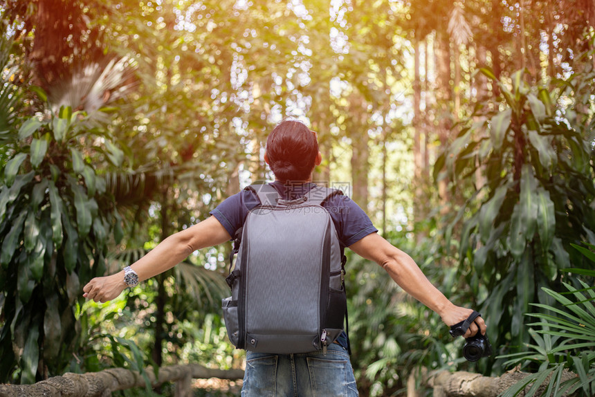一种自由旅行者男子与举起的手站在一享受着美丽的自然在日落时欢呼年轻节假日概念旅行时间不长景观常设图片