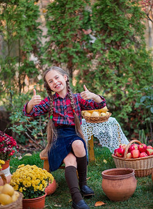 落下可爱的小女孩在秋天花园里抱着南瓜庆祝秋收可爱的小女孩在秋天花园里抱着南瓜人们幸福背景图片