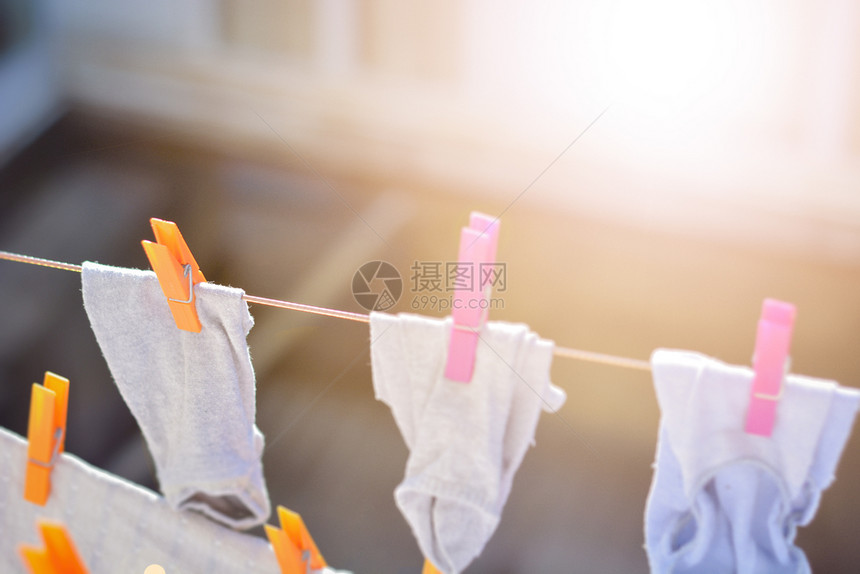 别针干净的棉布衣服线上挂着洗物在阳光下烘干图片