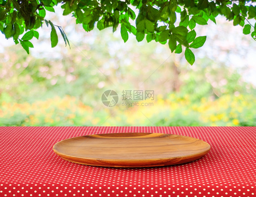 散景红色波尔卡圆点桌布上的空木板盘在有bokoh背景的模糊树上产品显示蒙戴海报桌上图片