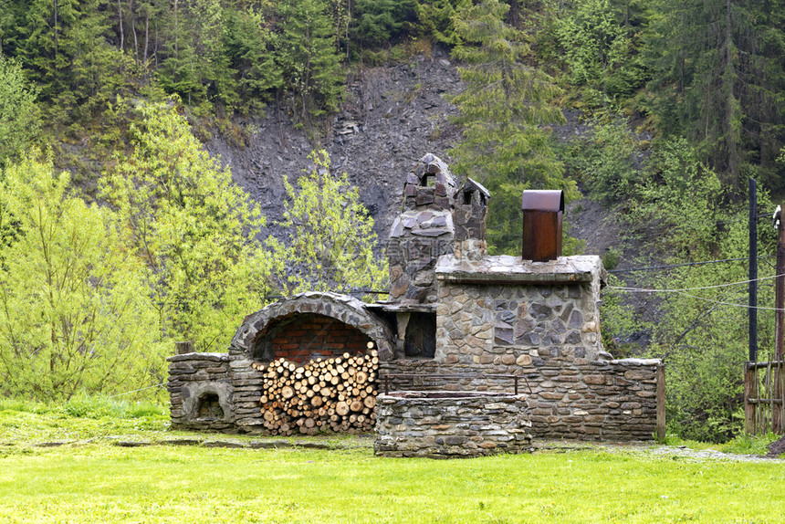 在喀尔巴阡山街头用木柴和烟屋做饭的老石头炉在喀尔巴阡山上用木柴和烟屋做饭的老石头炉一种家历史的图片