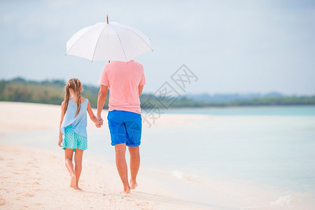 海边爸爸和女儿在海边行走图片