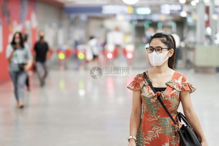 地铁里戴口罩预防流感的女性图片