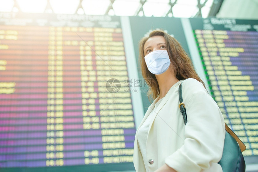 自由国际的女士戴面罩以防止在国际机场携带行李的在国际机场保护防止科罗纳和抓托克的妇女在国际机场携带行李的年轻女旅游客第6条图片