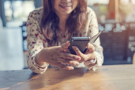 商业移动的亚裔女使用智能手机购物网站的智能手机与微笑脸面的幸福藉手持机在网上购物站进行邮件检查的年轻女阅读文章Blogvlog社背景图片