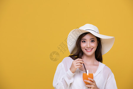 淑女帽女士丰富多彩的随意肖像亚洲美丽快乐的年轻女子戴着帽笑得很开心夏天拿着一杯橙汁看黄色工作室背景中突显的相机背景