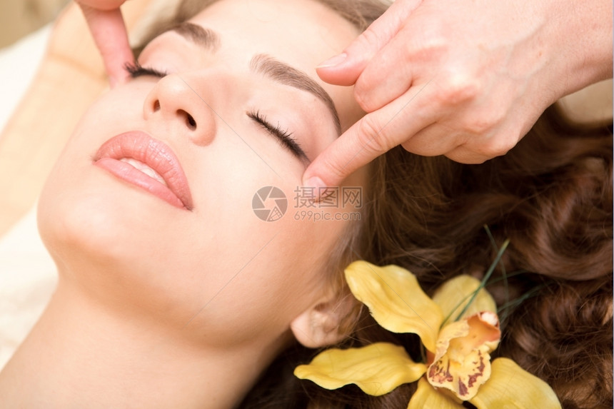 健康又的SPA年轻又漂亮放松的女人做面部按摩兰花长棕色头发活力卫生保健水平的图片
