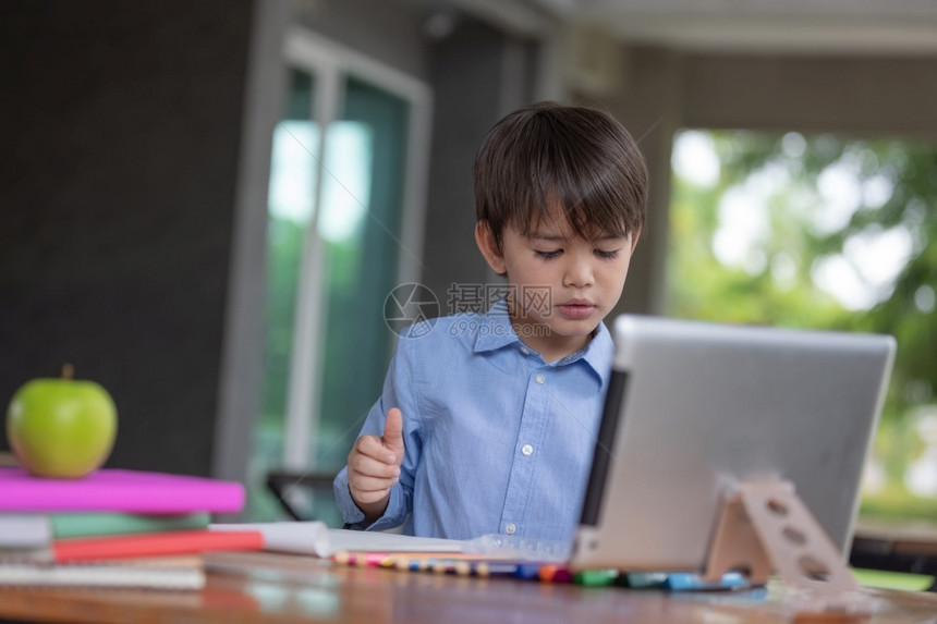 使用平板电脑做功课的小男孩图片
