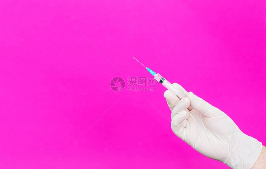 外科医生白手套持注射器Syringe医生手上有疫苗或麻醉剂闭合复制空间红色背景药品护士图片