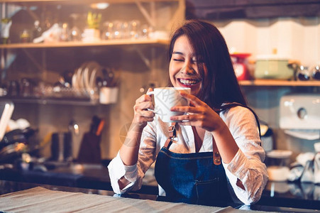 美丽的茶欢乐亚裔女咖啡家拿着一杯咖啡和调味品她自己煮咖啡与馆餐厅背景服务员在餐饮自助厅做客食品和饮料人们的生活方式与职业概念热的背景图片