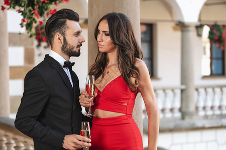新的在豪华派对期间坐在阳台上的一对有酒喝或香槟的情侣美丽的奢华图片