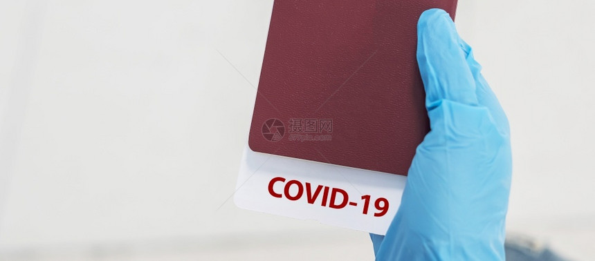 生病的新手戴硝化尼微套护照上贴有COVID19注解的护照对游客进行检疫保护科罗纳疾感染根据COVID19概念的新常态和旅行抓住图片