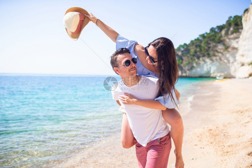 田园诗般的阳光夏天快乐家庭享受蜜月在海边的相片上幸福夫妇在海滩上的太阳镜中度过快乐的一对情侣图片