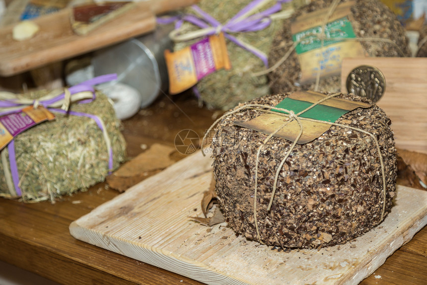 木制的带奶酪起司Hay盖在木制餐桌起司上带海罩在木制餐桌上传统的意大利语图片