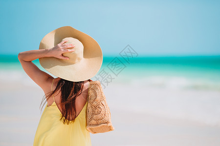 宁静天空在海滩上戴着帽子的漂亮女人背影年轻美丽的女士在热带海滨玩得开心快乐女孩的背景是蓝天和西里伯恩岛海水中的绿石闲暇背景图片