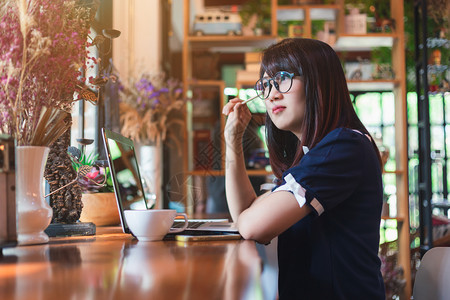 亚洲人书在线的咖啡店做笔记的亚洲年轻商业女青工作记录在咖啡店做笔记就像背景一样图片