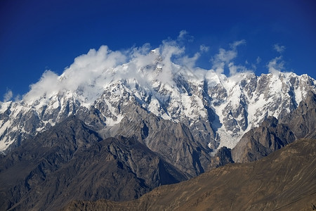 萨尔科姆蓝色的BaturaMuztagh云后面的乌尔塔萨山峰卡拉科姆山脉位于巴基斯坦吉尔特俾提斯坦Hunza山谷生态在后面背景