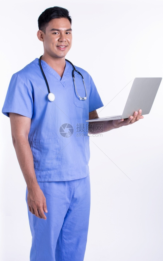 医疗的亚洲青年男医生身穿制服使用笔记本电脑在线服务同时站在白色背景上复制空间医疗与技术概念副本的亚洲年轻男医生微笑在线的图片
