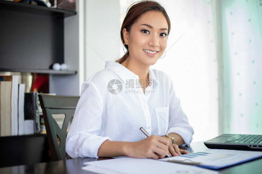 亚洲美丽的商业妇女检查文件并使用笔记本在家中工作以达到社会距离和自我责任概念亚洲美丽的商业女人学习屋成功图片