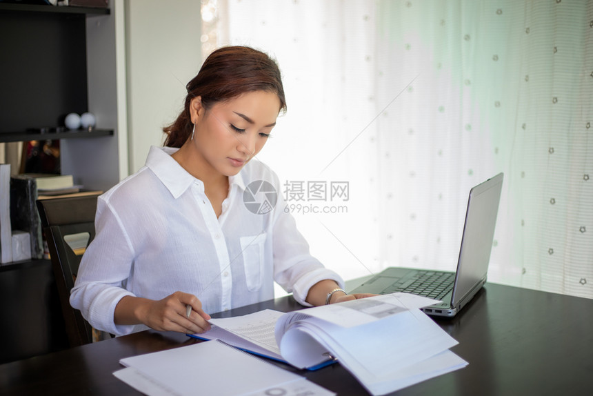 亚洲美丽的商业妇女检查文件并使用笔记本在家中工作以达到社会距离和自我责任概念亚洲美丽的商业女人电脑成年轻的图片